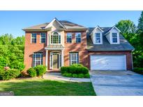 Charming two-story brick home featuring a well-manicured lawn and attached two car garage at 155 Cottage Cir, Fayetteville, GA 30215
