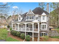 Stately two-story home featuring a covered front porch, stone accents, and professional landscaping at 600 Lake Overlook Dr, Canton, GA 30114