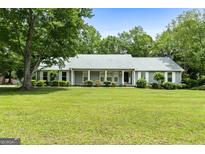 Charming single-story home with lush green lawn, mature trees and gray shutters at 41 Ridgewood Cir, Mcdonough, GA 30252