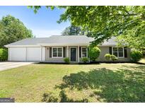 Charming single-story home with manicured lawn, two-car garage, and a welcoming front porch at 1425 Meadowind Court Sw, Conyers, GA 30094