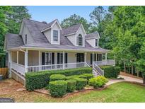 Charming two-story home with a welcoming front porch and well-manicured landscaping at 212 Warrenton Dr, Douglasville, GA 30134