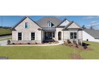 Beautiful, light brick single Gathering home with manicured front yard and walkway to the covered front door at 227 Laurel Vista Dr., Canton, GA 30114