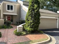 Charming home featuring a red front door, brick pathway, a 2 car garage, and mature landscaping at 3192 Paces Mill Se Rd, Atlanta, GA 30339