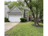 Exterior view showcasing a two-story home with attached garage, lush landscaping, and mature tree at 3838 Kirkwood Nw Run, Kennesaw, GA 30144