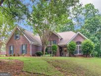 Charming brick home featuring a lush green lawn and mature trees, showcasing classic Southern architecture at 1585 Lake Dow Rd, Mcdonough, GA 30252