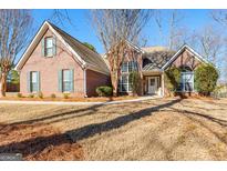 Charming brick home with a well-manicured front lawn and beautiful landscaping at 1585 Lake Dow Rd, Mcdonough, GA 30252