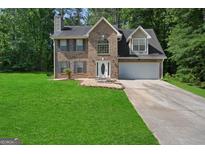 Two-story brick home featuring blue shutters, attached two-car garage and well-maintained lawn at 96 Ashtonbrook Dr, Mcdonough, GA 30252