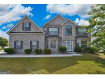 Beautiful two-story home featuring a brick facade, well-manicured lawn, and a welcoming front entrance at 1441 Saint George Pl, Conyers, GA 30012
