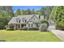 Charming home with a well-manicured lawn, dormer windows, and a welcoming facade exudes curb appeal at 465 Crabapple Rd, Fayetteville, GA 30215