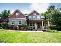 Charming two-story home featuring a welcoming front porch, beautifully landscaped lawn, and traditional architectural details at 125 High Bluff Trl, Carrollton, GA 30116