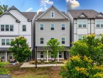 Charming townhome with gray siding, a covered front porch, and manicured landscaping at 2108 Remy Ct, Kennesaw, GA 30144