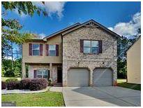 Charming two-story home featuring a brick facade and a two-car garage at 620 Sedona Loop, Hampton, GA 30228