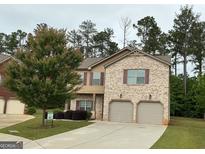 Two-story home with a two-car garage, manicured lawn, and a combination of brick and siding exterior at 620 Sedona Loop, Hampton, GA 30228