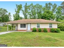 Charming single-story home featuring a well-maintained lawn and a brick-accented foundation at 840 Jett Rd, Jonesboro, GA 30236