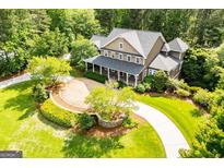 Expansive home featuring a front porch, beautiful landscaping and a circular driveway at 115 Champion Dr, Carrollton, GA 30116
