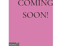 Real estate listing with text 'Coming Soon' on a pink background, indicating the property will be available soon at 1928 Stancrest Nw Trce, Kennesaw, GA 30152