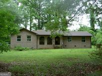 Charming brick home with a front porch and green lawn at 981 E Atlanta Rd, Stockbridge, GA 30281