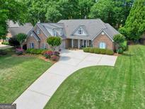 Beautiful brick home with a well-manicured lawn and a long driveway at 211 English Oaks Ln, Mcdonough, GA 30253