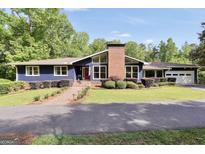 Charming home featuring a brick chimney, large windows, well-manicured lawn, and inviting curb appeal at 200 Camp Creek Trail, Peachtree City, GA 30269