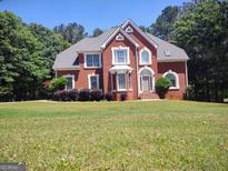 Charming brick home with a well-manicured lawn and beautiful landscaping at 308 Bell Isle, Mcdonough, GA 30252