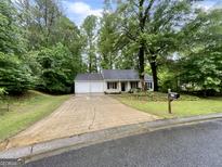 Charming single-story home featuring a two-car garage and a well-maintained front yard at 6026 Woodcreek Dr, Woodstock, GA 30188