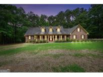 Charming brick home featuring a welcoming front porch and lush green lawn at 428 Turner Rd, Mcdonough, GA 30252