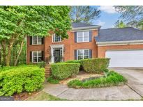 Charming two-story brick home with a well-manicured lawn and lush landscaping at 4250 Edgewater Nw Ct, Kennesaw, GA 30144