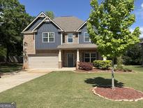 Beautiful two-story home with brick and siding, manicured lawn, and attached two-car garage at 101 Elkins Blvd, Locust Grove, GA 30248