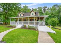 Charming two-story home featuring a welcoming front porch with white railings and a well-manicured lawn at 3777 Edward Rd, Rex, GA 30273