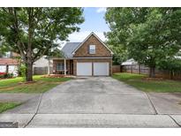 Charming brick home with a well-maintained lawn and a two-car garage at 1871 Sandy Trail Dr, Hampton, GA 30228
