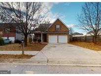 Charming two-story home featuring a brick facade, double garage, and well-maintained front yard at 1871 Sandy Trail Dr, Hampton, GA 30228