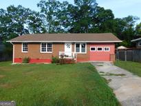 Charming brick ranch with red trim and an attached garage at 5243 Eubanks Dr, Lake City, GA 30260