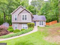 Charming two-story home with a landscaped yard, quaint shed, and welcoming walkway at 10 Queens Ct, Sharpsburg, GA 30277
