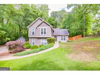 Charming two-story home with manicured lawn, mature trees, and inviting curb appeal at 10 Queens Ct, Sharpsburg, GA 30277