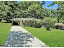 Charming ranch home with a long driveway and a covered carport surrounded by lush greenery at 2165 Pemberton Rd, Atlanta, GA 30331