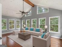 Bright living room featuring a vaulted ceiling, many windows, and hardwood flooring at 230 Shorewood Ct, Mcdonough, GA 30252