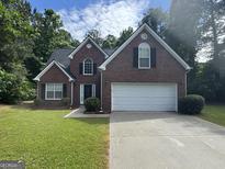 Charming brick home with a two-car garage and well-manicured lawn at 4551 Mitchells Meadow Ln, Ellenwood, GA 30294
