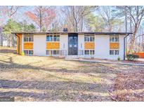 Charming brick home with modern wood accents, large windows, and beautifully landscaped front yard at 2541 Peyton Woods Sw Trl, Atlanta, GA 30311