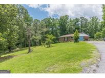 Charming single-story brick home with a well-maintained lawn and mature trees at 5255 Post Rd, Winston, GA 30187