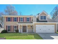 Charming two-story home with a well-manicured lawn, a two-car garage, and a welcoming front porch at 1416 Emerald Pine Ct, Lawrenceville, GA 30043