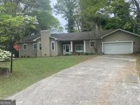 Charming one-story home with a front yard, mature trees, and a paved driveway leading to an attached garage at 191 Lagrange Street, Grantville, GA 30220