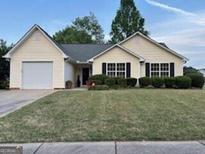 Charming one-story home with a well-manicured lawn and attached garage at 486 Village Cir, Stockbridge, GA 30281