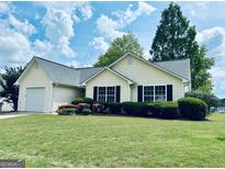 Charming one-story home with a well-manicured lawn and vibrant landscaping at 486 Village Cir, Stockbridge, GA 30281