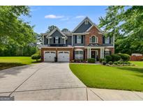 Beautiful two-story home with a well-manicured lawn, two-car garage and a brick and siding exterior at 7115 Secret Rose, Douglasville, GA 30134