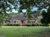 Charming brick home with a well-manicured lawn and mature landscaping, creating inviting curb appeal at 2451 Old Salem Se Cir, Conyers, GA 30013