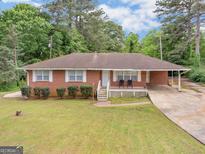 Charming single story brick home with well-manicured lawn and attached carport at 2609 Lake Harbin Rd, Morrow, GA 30260