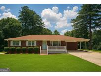 Charming brick home features a well-manicured lawn and covered front porch at 2609 Lake Harbin Rd, Morrow, GA 30260