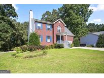 Charming two-story brick home with blue shutters and well-manicured lawn, offering classic curb appeal at 3161 Pagoda Trce, Lawrenceville, GA 30043