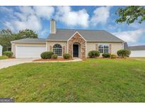 Charming single-story home features stone accents, neutral siding, attached garage, and a well-maintained lawn at 5669 Blackberry Row, Ellenwood, GA 30294