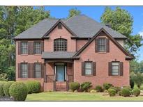 Charming brick home with a well-manicured lawn and a welcoming blue front door at 225 S South Shore Ter, Fayetteville, GA 30214